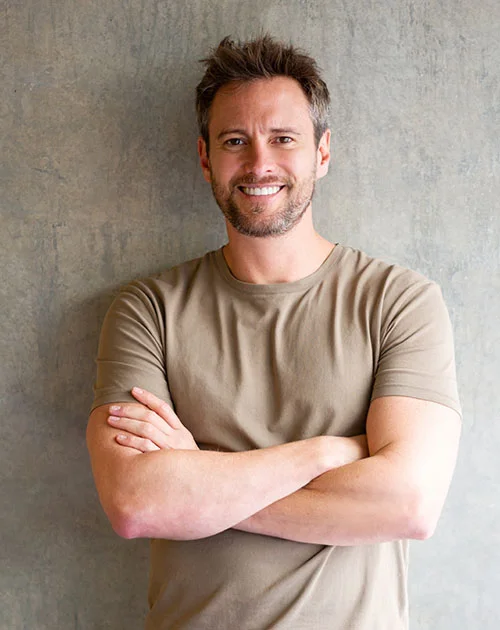 Man leaning up against a wall with his arms folded